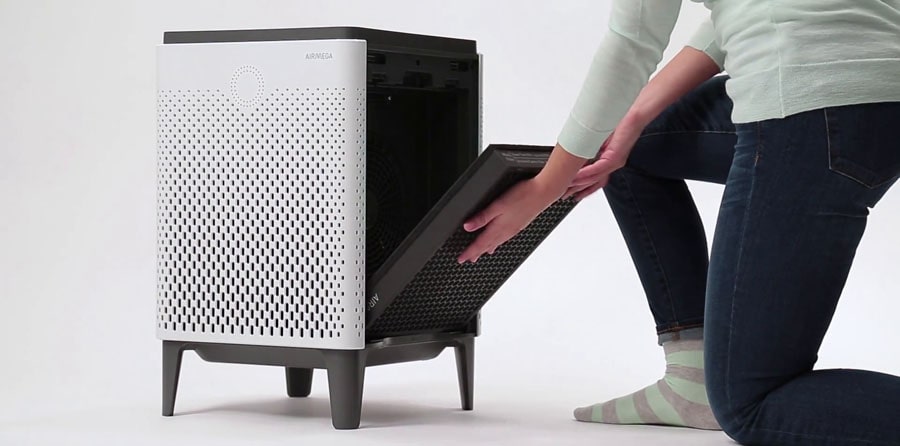 Woman replaces air filter in the air purifier.