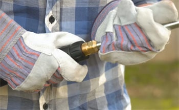 Man prepares the pressure washer for cleaning job.