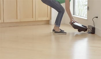 Woman helps the Neato D7 to find it's charging base.