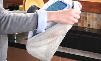A woman prepares mop's pad for laundering.