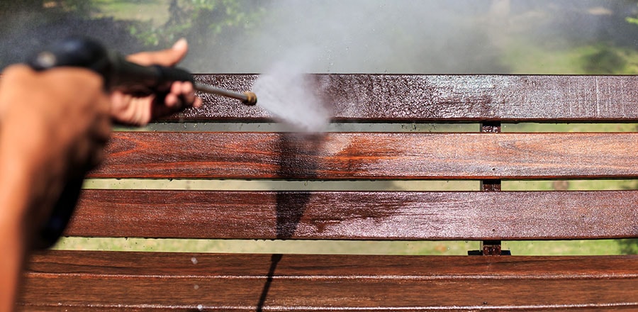 Man washing the garden bench.