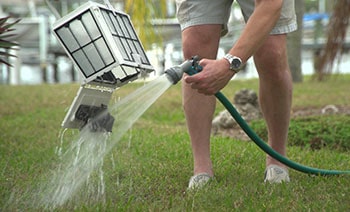 A man back washes the robot's filter.