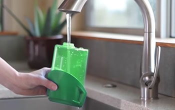 Woman fills the BGST1566 water container with the tap water.