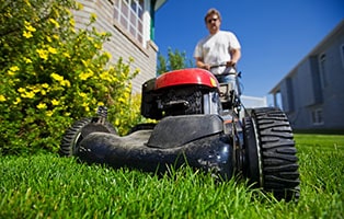 Man mows a lawn on his yard.