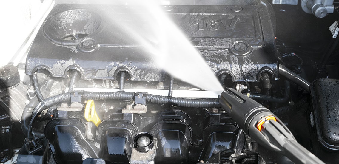 Man washes his car engine.