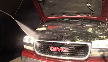 GMC truck owner is washing the engine bay of his car