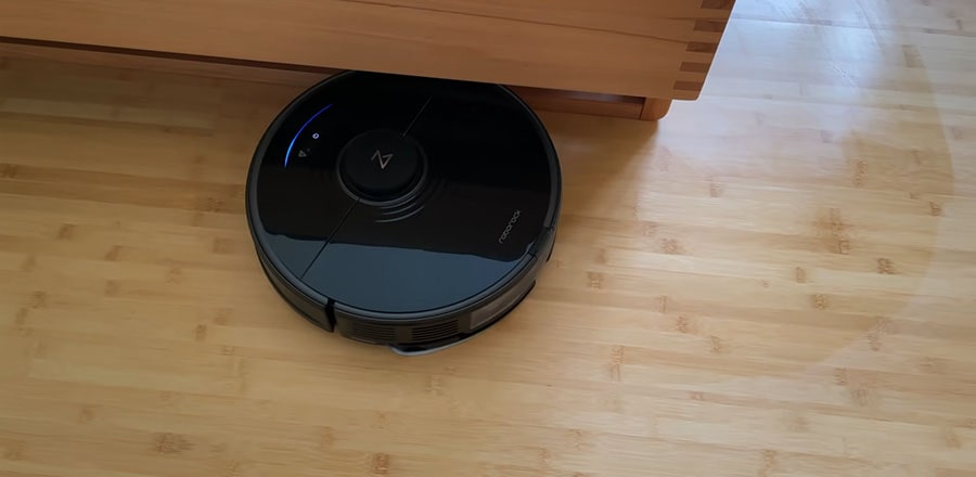 Roborock S7 cleans a hardwood floor of the bedroom.