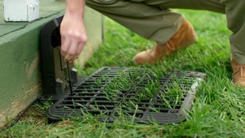 A man installing the docking station for the robotic lawn mower.