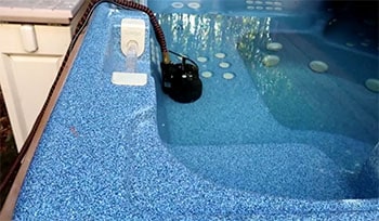 A submersible pump drains the pool