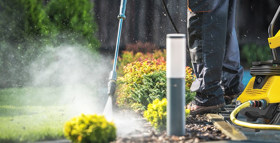 A man cleans the yard with the electric pressure washer from Stanley.