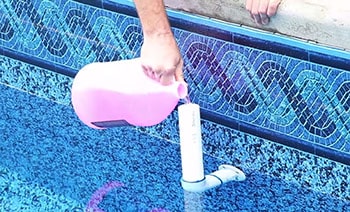 Man fills the swimming pool pipes with a non-toxic antifreeze
