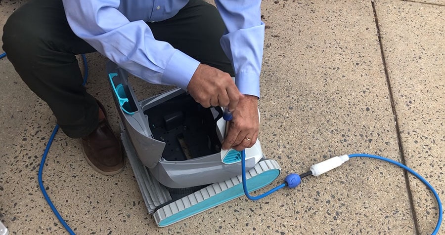 Man disassembles the robotic pool cleaner for maintenance