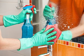 Woman cleaning a mirror.