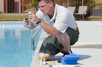 Man measures pool water calcium hardness.