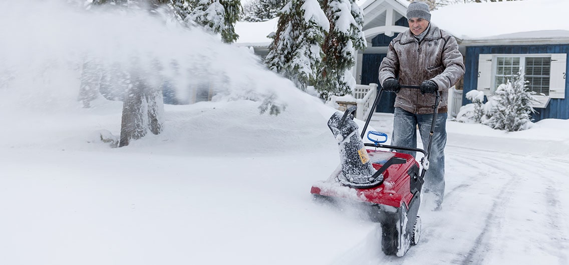 Man clears snow from his driveway.