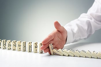 Hand stopping the domino falls