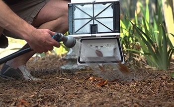 Man hosing the filter of the pool cleaning robot.