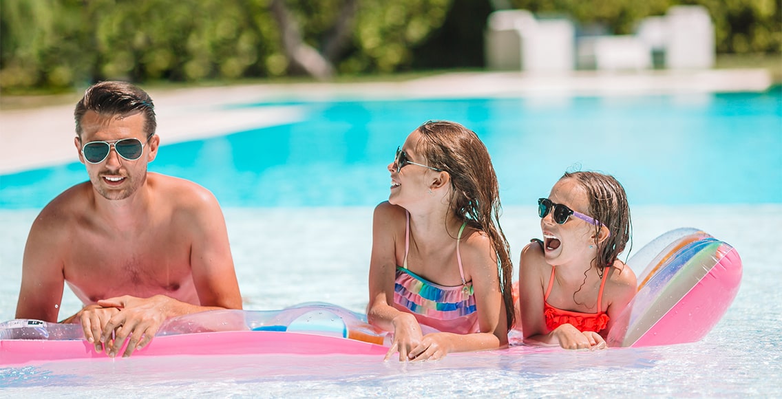 Family swimming in the clean pool