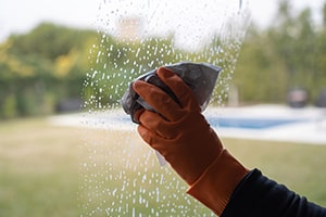 Man is cleaning the window with newspapers