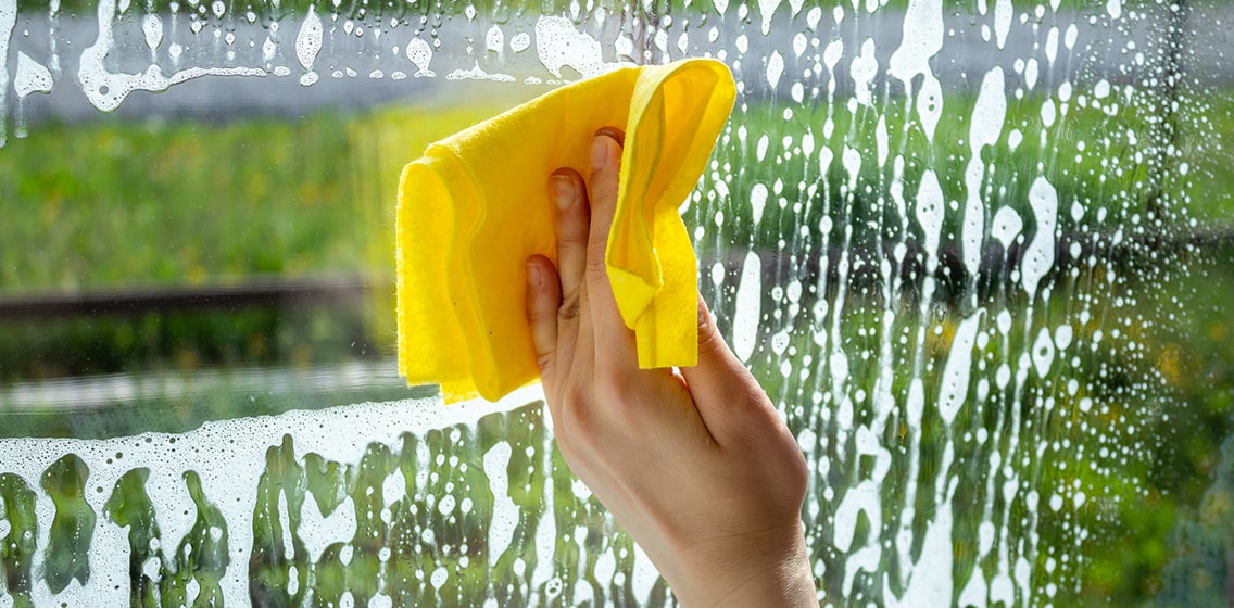 Woman is cleaning the window