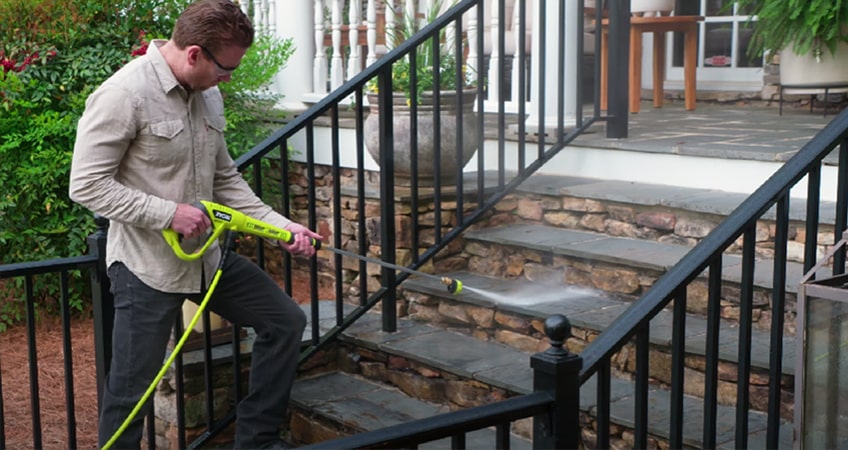 Man is cleaning the stairs with the Ryobi RY80942 3300 PSI