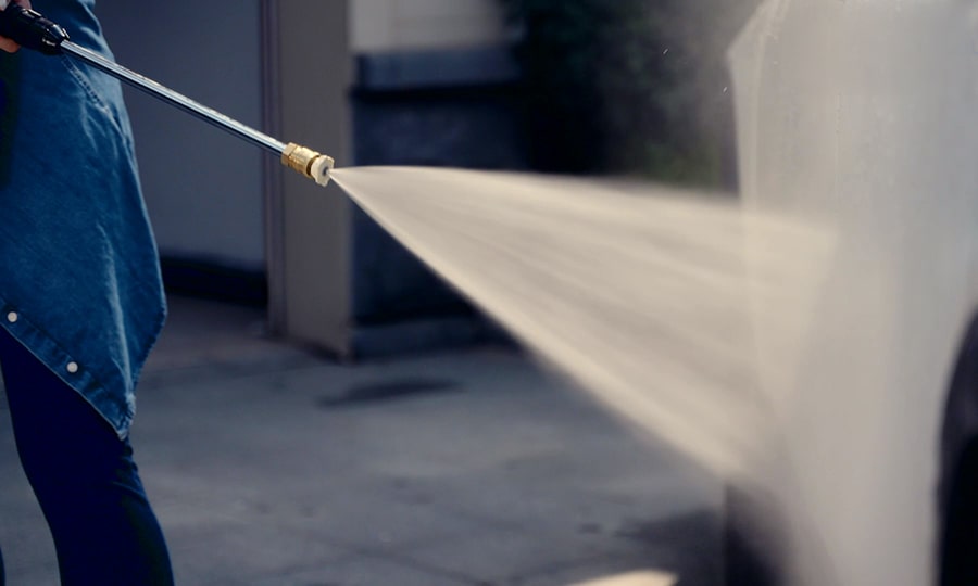 Woman is washing her car with Giraffe Tools Grandfalls Electric Pressure Washer